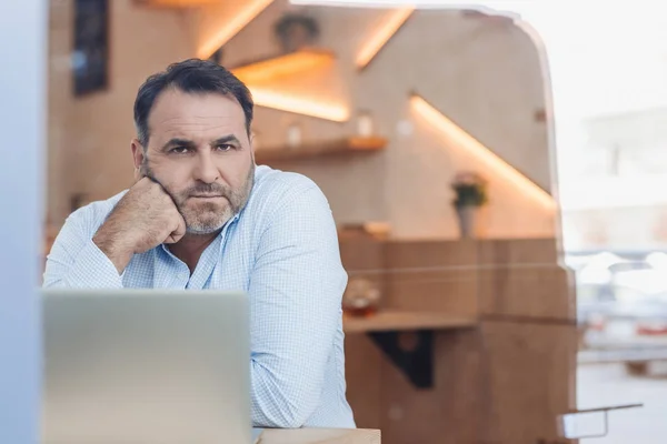 Empresario con portátil en la cafetería - foto de stock