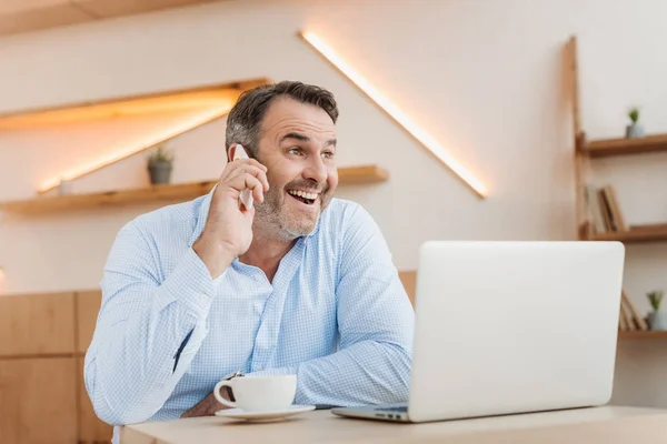 Hombre de negocios feliz hablando por teléfono en la cafetería - foto de stock