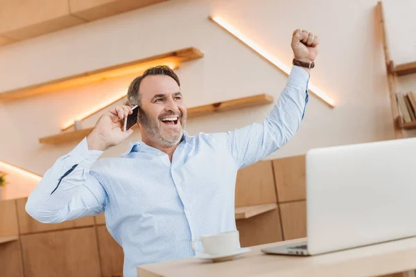 Hombre de negocios feliz hablando por teléfono en la cafetería - foto de stock