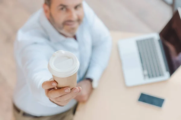 Бізнесмен показує одноразову чашку кави — стокове фото