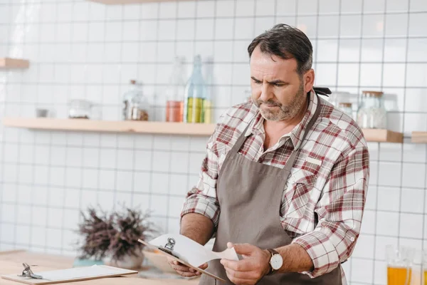 Barkeeper checkt Papier auf Klemmbrett — Stockfoto