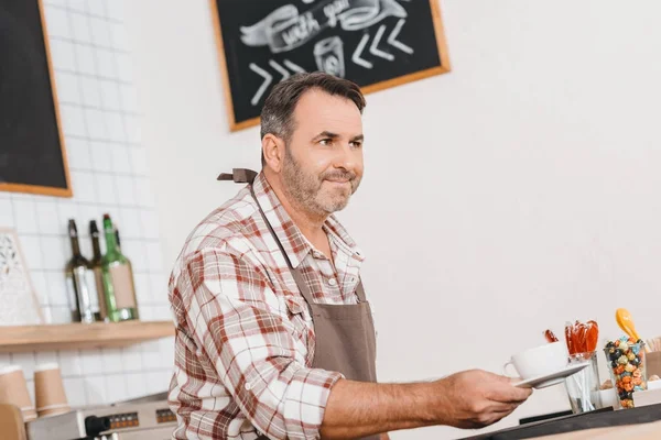 Bartender holding cup of coffee — Stock Photo