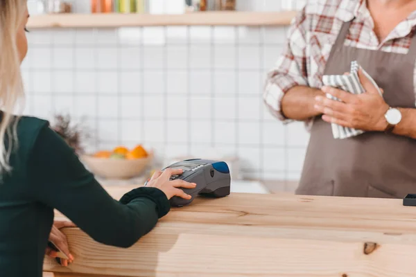 Donna che paga con pos terminale al caffè — Foto stock