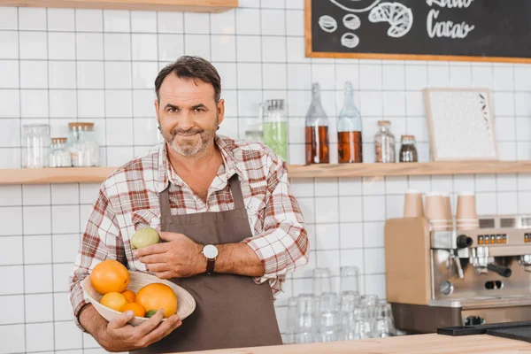 Bartender with bowl of fruits — Stock Photo
