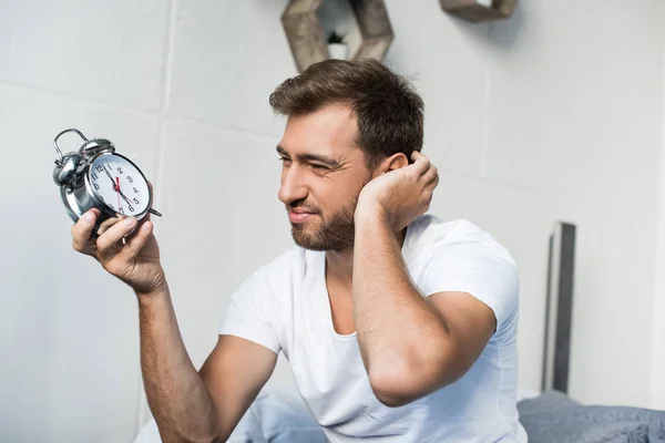 Homem segurando despertador — Fotografia de Stock