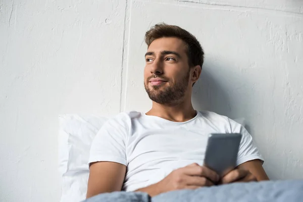 Mann benutzt Smartphone im Bett — Stockfoto