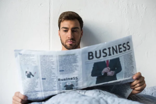 Mann im Bett liest Zeitung — Stockfoto