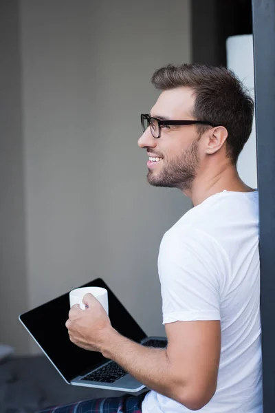 Man holding laptop and coffee — Stock Photo