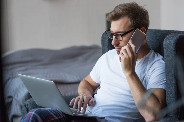 Man on phone using laptop — Stock Photo