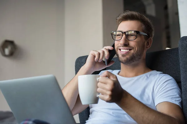 Man with coffee talking on smartphone — Stock Photo