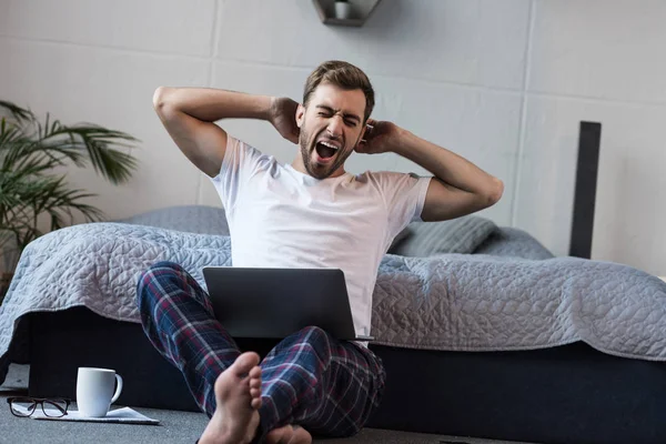 Sleepy man using laptop — Stock Photo