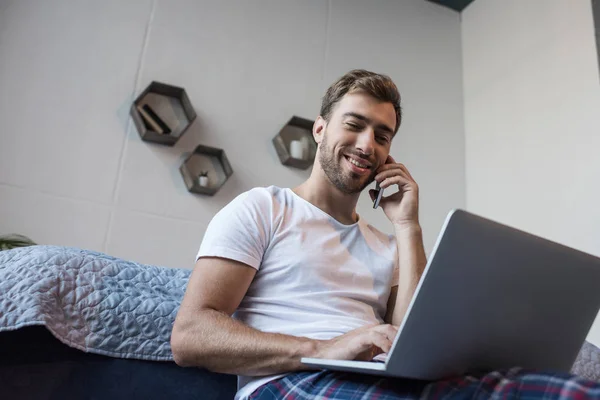 Man on phone using laptop — Stock Photo