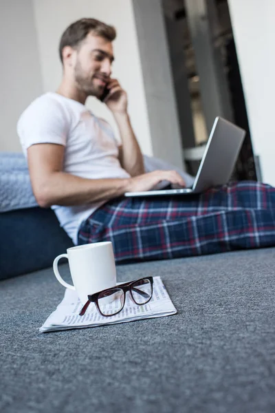 Man on phone using laptop — Stock Photo