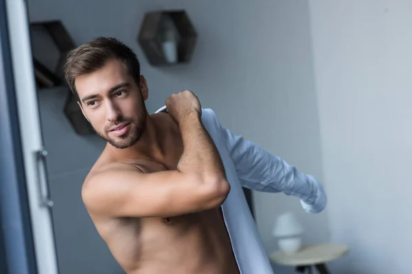 Hombre poniéndose la camisa - foto de stock