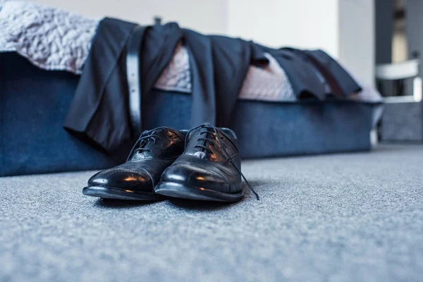 Traje formal na cama e sapatos de couro — Fotografia de Stock
