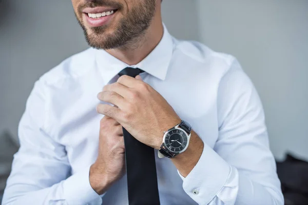 Businessman putting on tie — Stock Photo