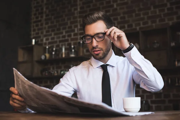 Hombre de negocios en la cafetería leyendo periódico - foto de stock