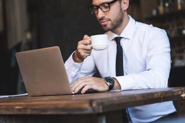 Empresario con café y portátil - foto de stock