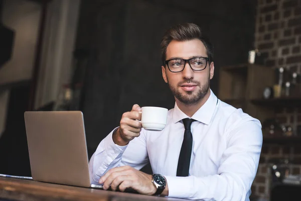 Businessman at cafe with laptop — Stock Photo