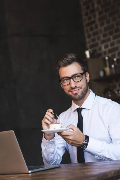 Homme d'affaires manger gâteau au café — Photo de stock