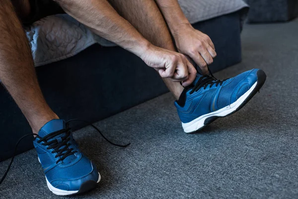 Hombre atando cordones en zapatilla - foto de stock