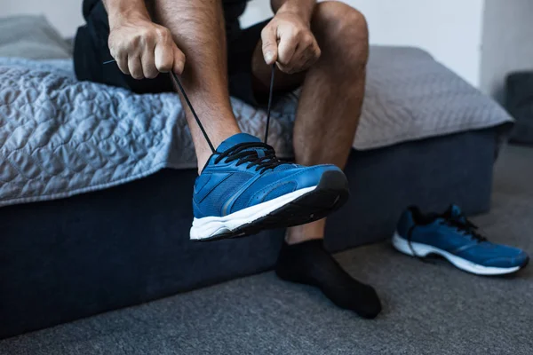 Hombre atando cordones zapatilla - foto de stock