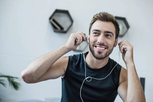 Hombre poniéndose auriculares - foto de stock