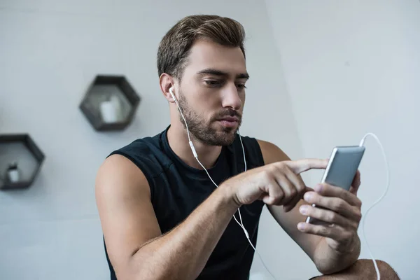 Homem atlético usando smartphone — Fotografia de Stock