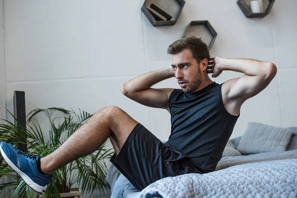Man exercising on bed — Stock Photo