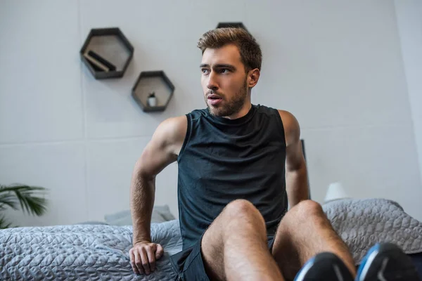 Мужчина делает упражнения для рук на кровати — стоковое фото