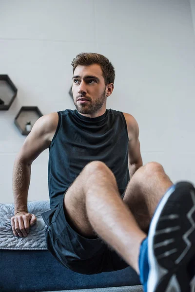 Man doing exercises in bedroom — Stock Photo