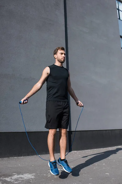 Athletic sportsman jumping with rope — Stock Photo