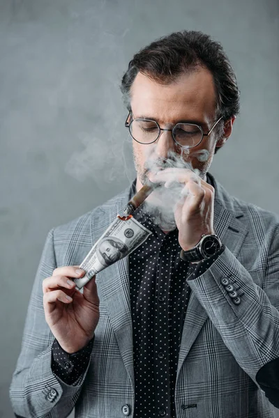 Businessman smoking cigar — Stock Photo