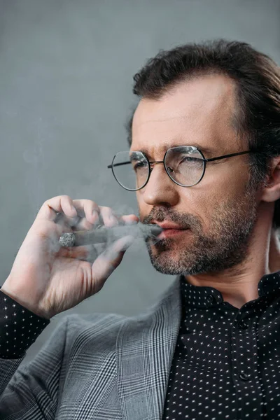 Businessman smoking cigar — Stock Photo