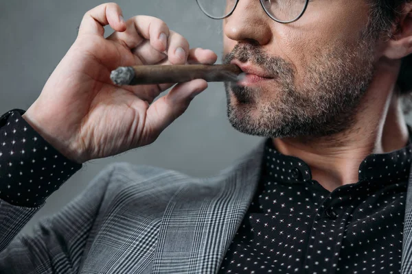 Businessman smoking cigar — Stock Photo