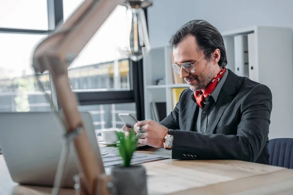 Hombre de negocios utilizando el ordenador portátil y smartphone - foto de stock
