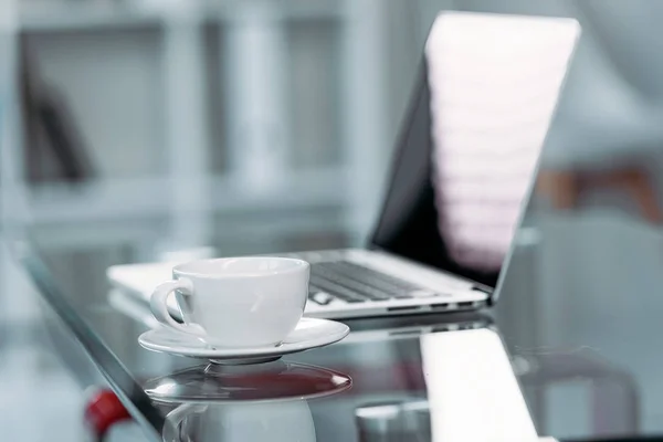 Tasse Kaffee und Laptop auf dem Tisch — Stockfoto