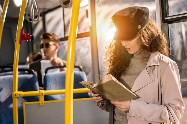 Girl reading book in bus — Stock Photo