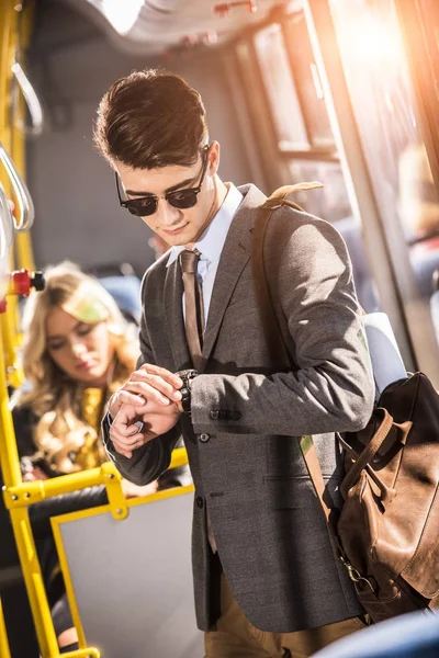 Uomo d'affari che controlla orologio da polso in autobus — Foto stock
