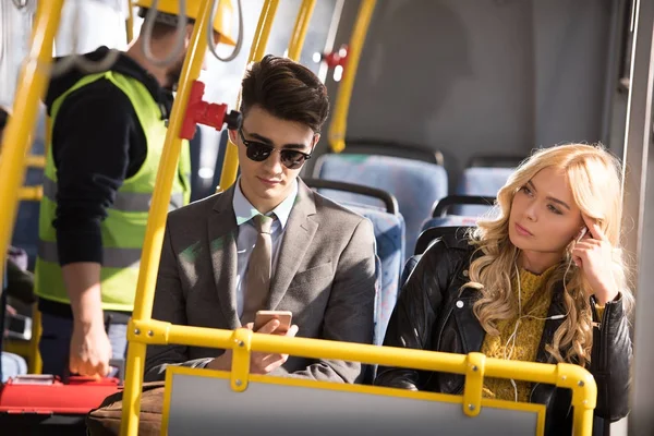 Casal com smartphone em ônibus — Fotografia de Stock