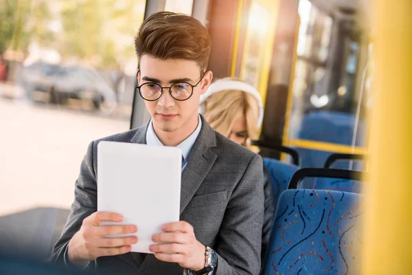 Homme avec tablette numérique en bus — Photo de stock