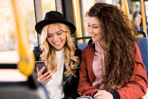 Девушки, использующие смартфон в автобусе — стоковое фото