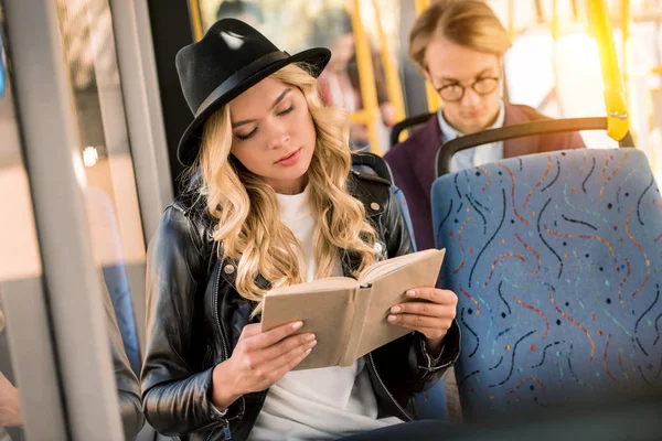 Girl reading book in bus — Stock Photo