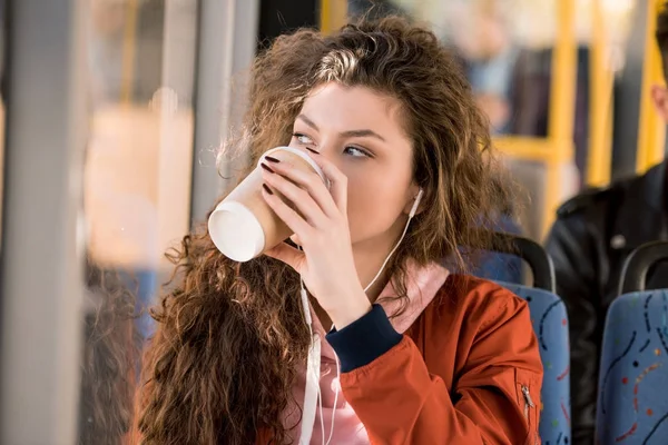 Girl drinking coffee in bus — Stock Photo