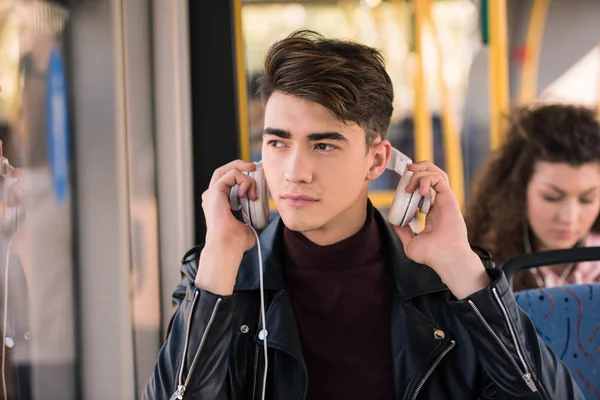 Hombre con auriculares en autobús - foto de stock