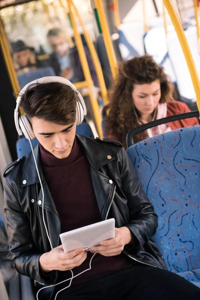 Homme dans les écouteurs avec tablette numérique — Photo de stock