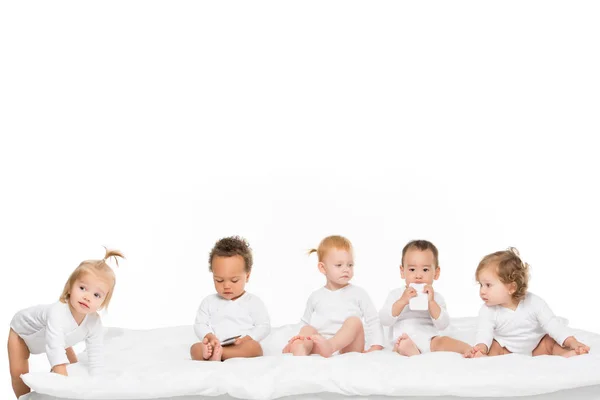 Niños pequeños multiculturales con smartphones - foto de stock