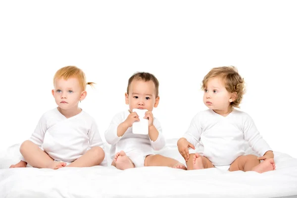 Niños pequeños multiculturales con smartphone - foto de stock