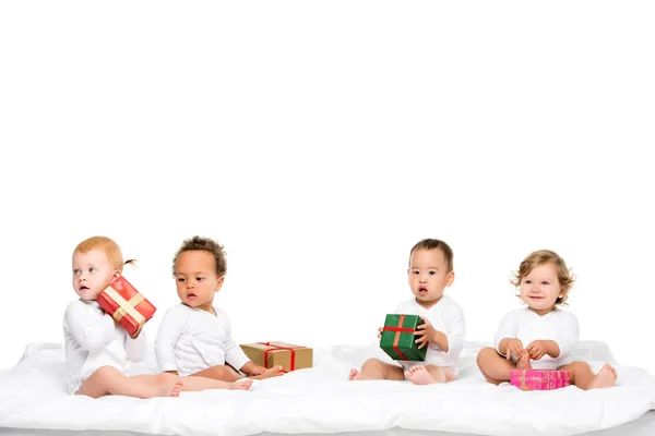 Niños multiétnicos con regalos envueltos - foto de stock