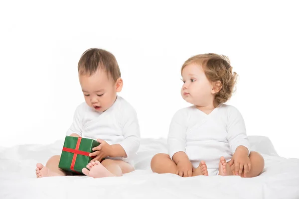 Niños multiétnicos con regalo envuelto - foto de stock